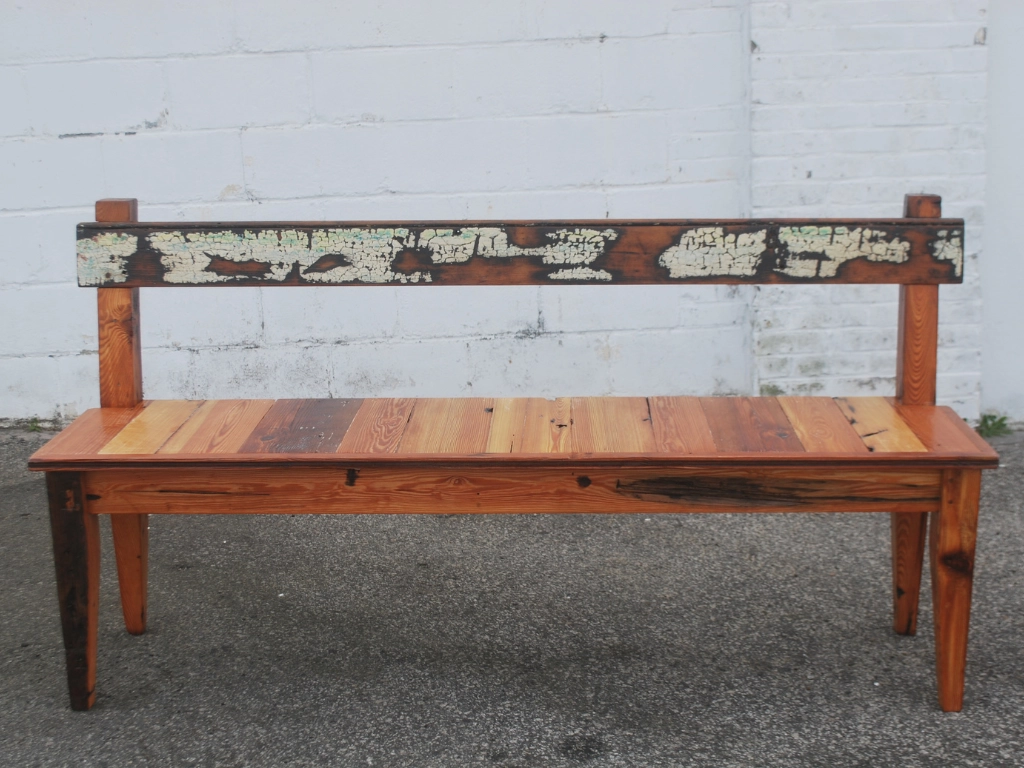 Reclaimed wood bench in front of a white wall